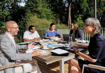 Group of people sitting at the table and talking friendly with each other.
